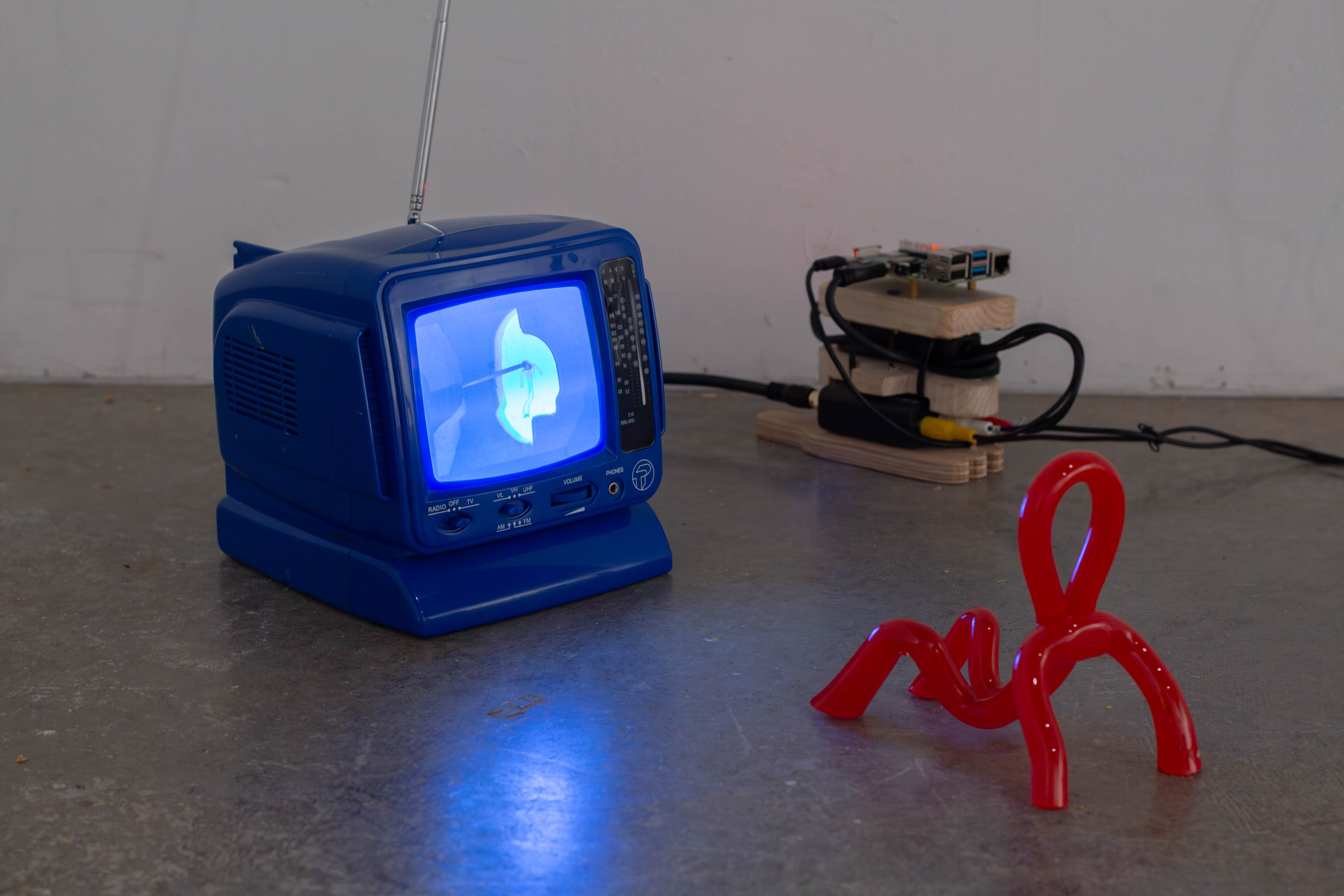 little glass person watching other glass people get tortured on tv